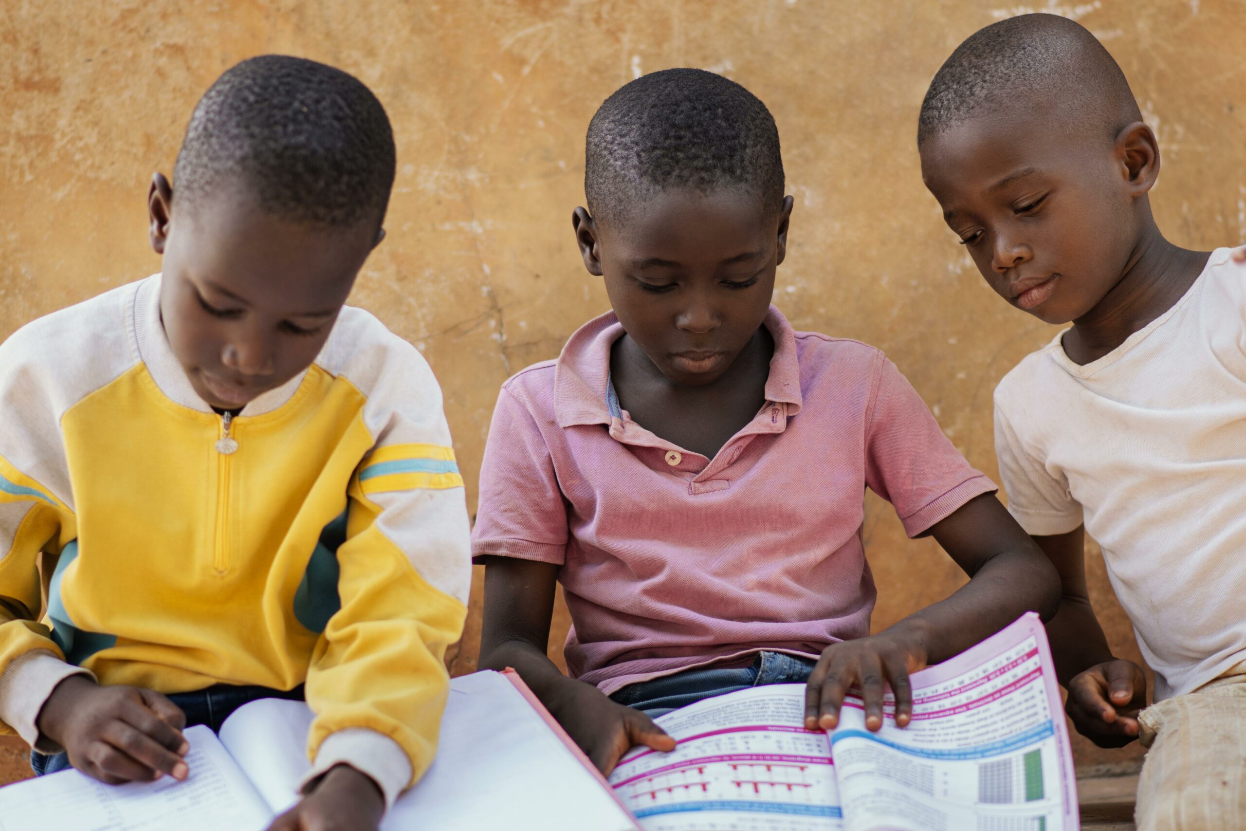 close up african kids reading together scaled