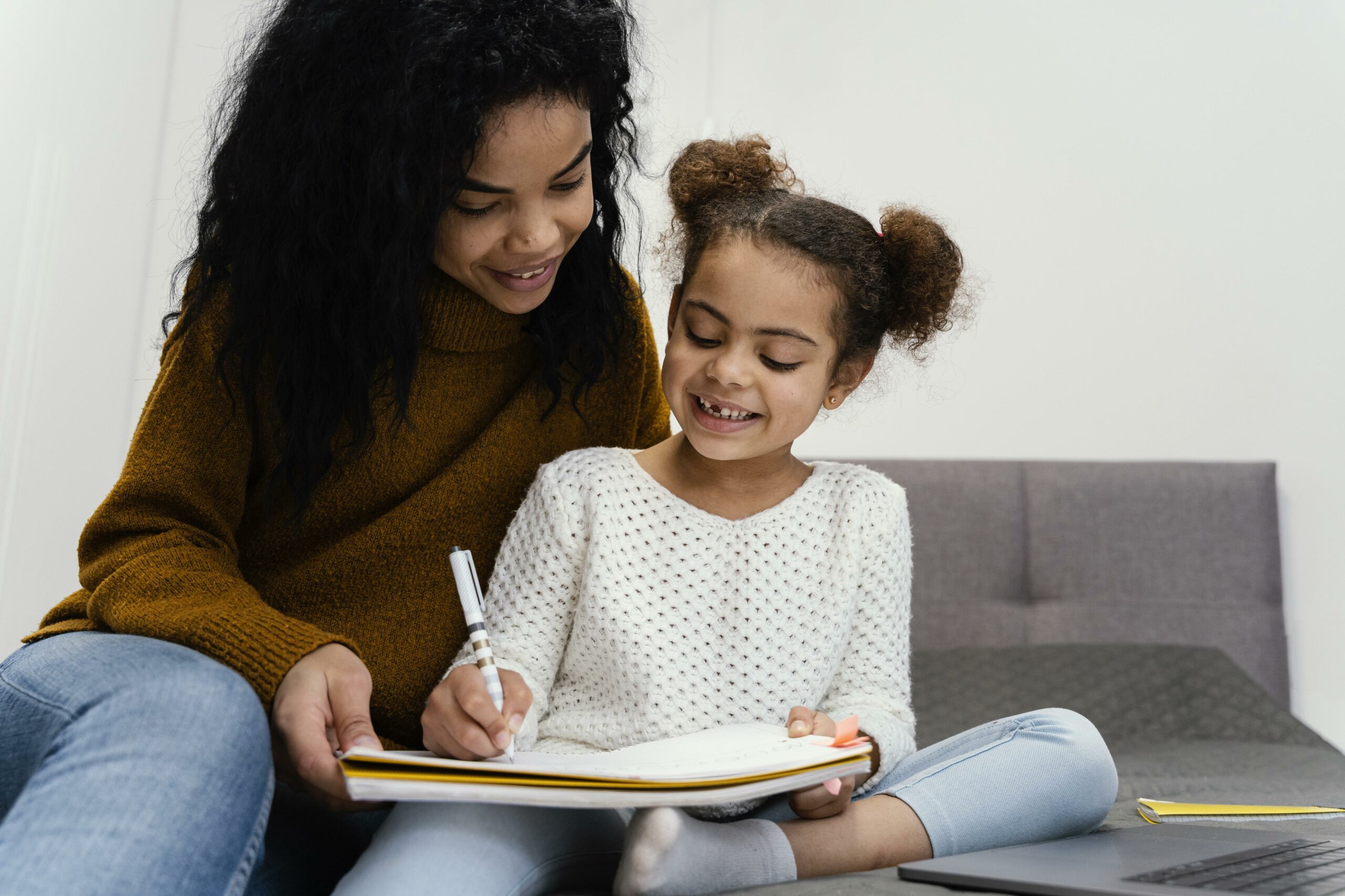 teenage girl helping sister with online school scaled